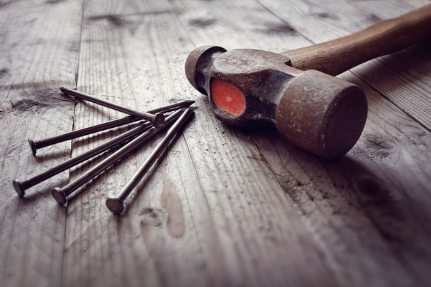 bigstock-Hammer-and-nails-on-floorboard-158701190.jpg